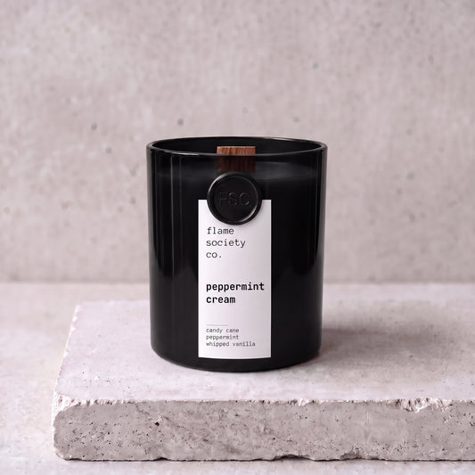 Peppermint Cream candle hero — black glass vessel with wooden wick, candy cane, peppermint and whipped vanilla — Flame Society Co.