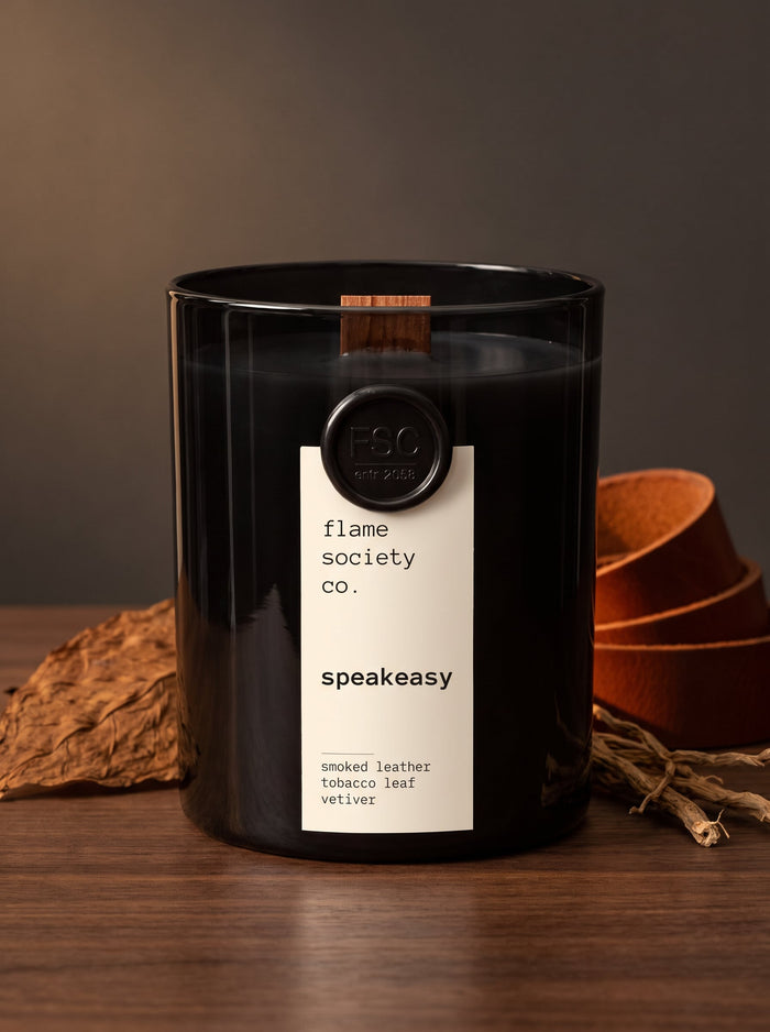 Speakeasy candle hero — glossy black vessel with wooden wick, smoked leather, tobacco leaf and vetiver — Flame Society Co.