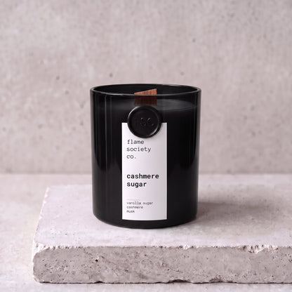 Cashmere Sugar candle hero — black glass vessel with wooden wick, vanilla sugar, cashmere and musk — Flame Society Co.