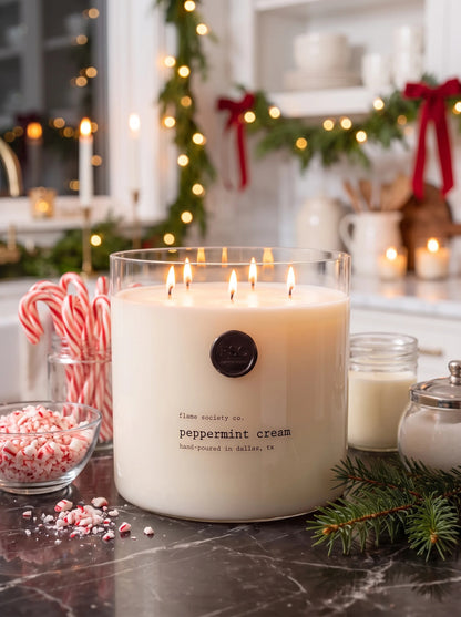 Peppermint Cream XL 150oz statement candle in a clear glass vessel in a holiday kitchen with candy canes — Flame Society Co.