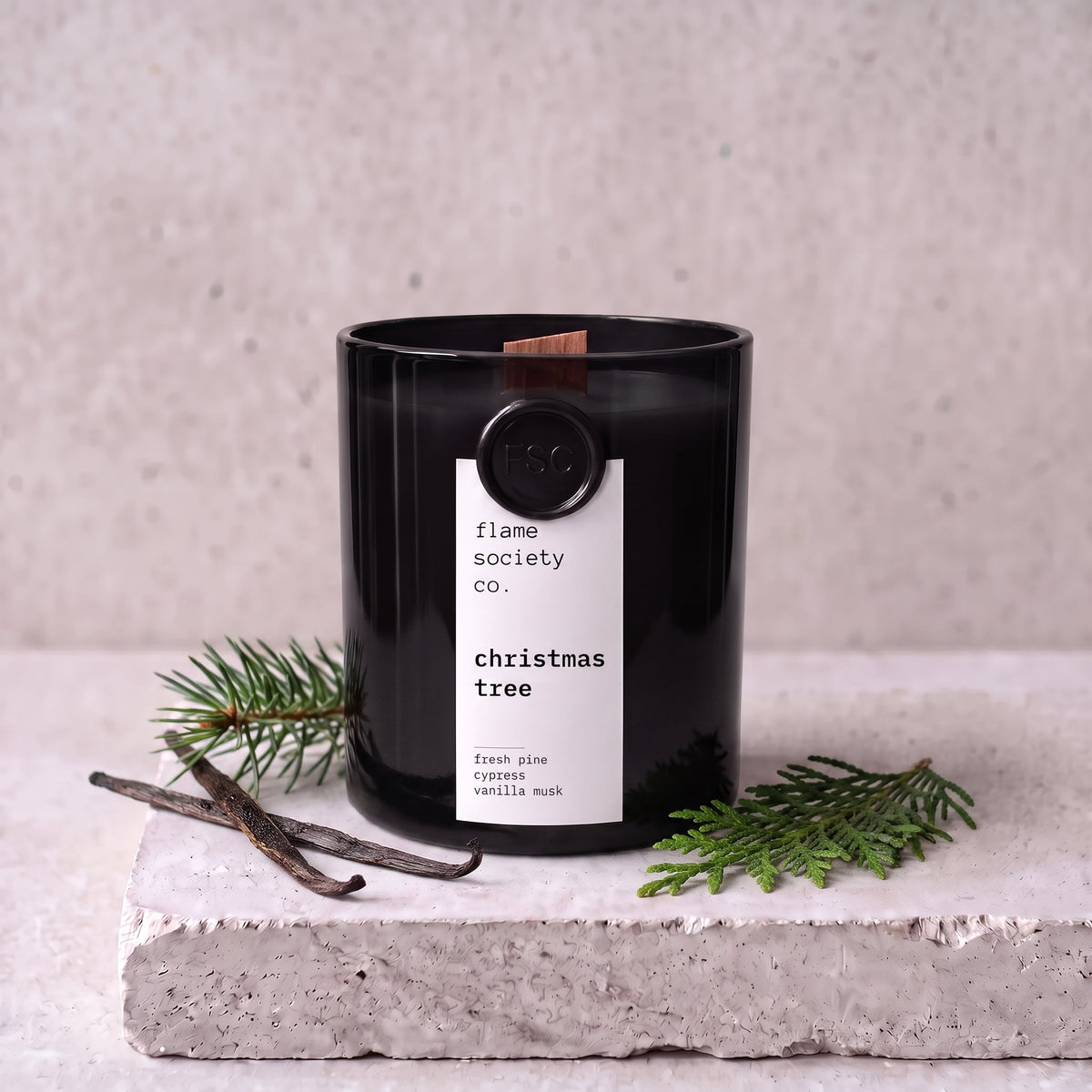 Christmas Tree candle styled with fresh pine, cypress and vanilla on concrete — Flame Society Co.