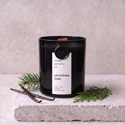 Christmas Tree candle styled with fresh pine, cypress and vanilla on concrete — Flame Society Co.