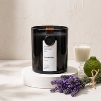 Flame Society Co. Lavender candle in black glass vessel with fresh lavender stems.