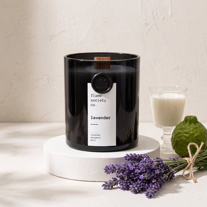 Flame Society Co. Lavender candle in black glass vessel with fresh lavender stems.