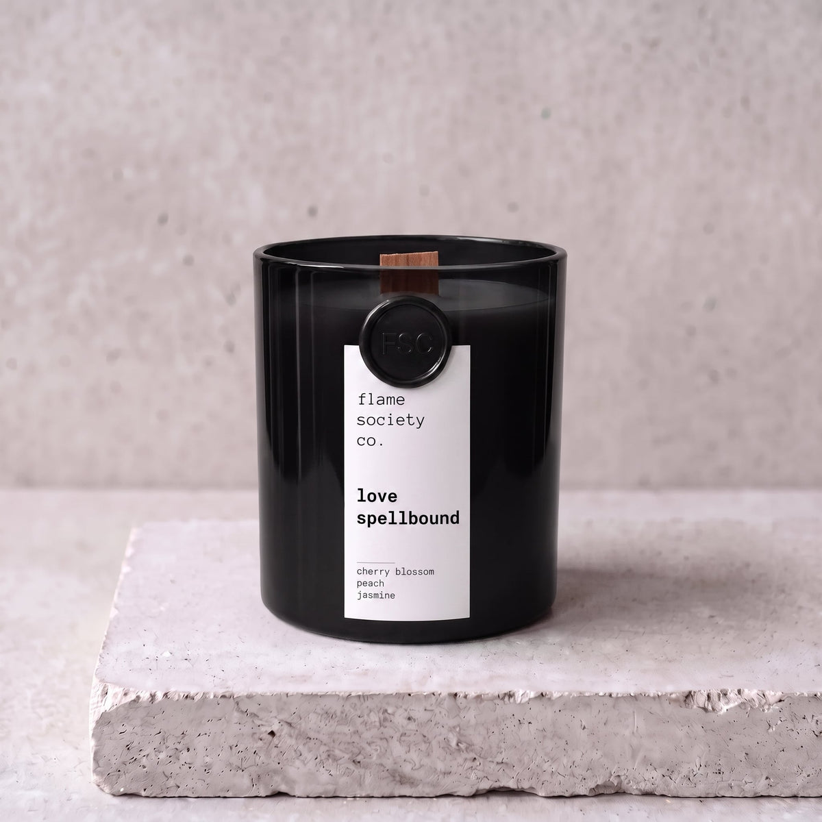 Love Spellbound candle hero — black glass vessel with wooden wick, cherry blossom, peach and jasmine — Flame Society Co.