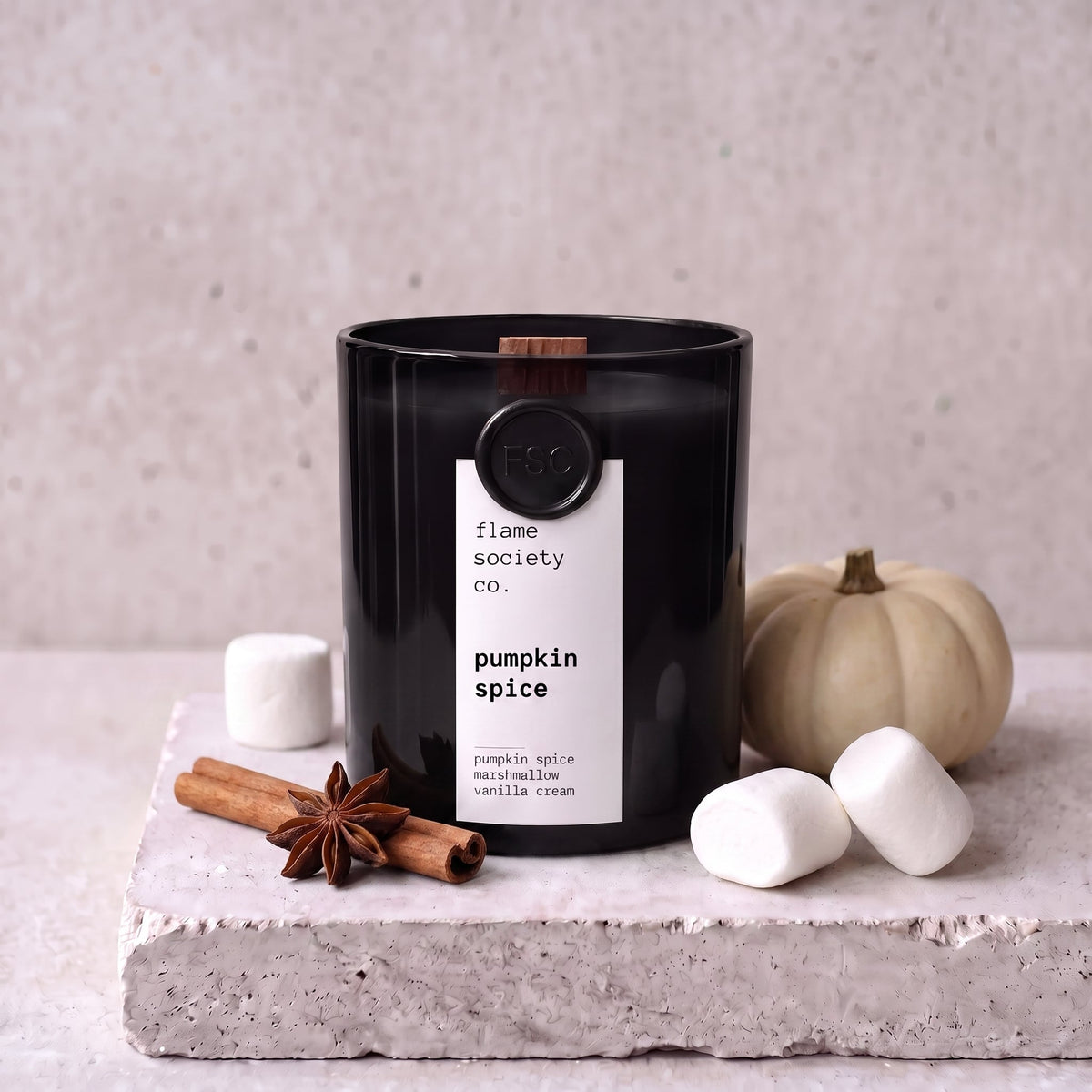 Pumpkin Spice candle styled with pumpkin, cinnamon and marshmallow on concrete — Flame Society Co.