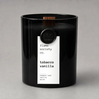 Black candle with a white label on a gray background