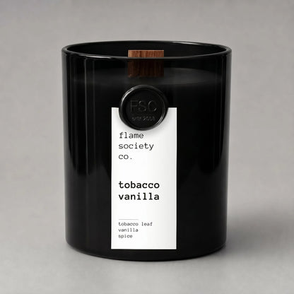 Black candle with a white label on a gray background