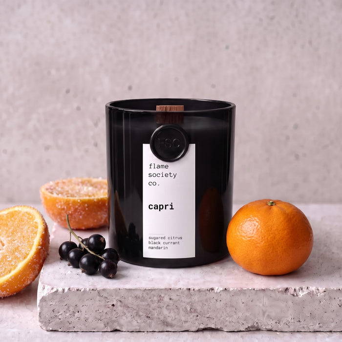 Capri candle styled with sugared citrus, black currant and mandarin on concrete — Flame Society Co.