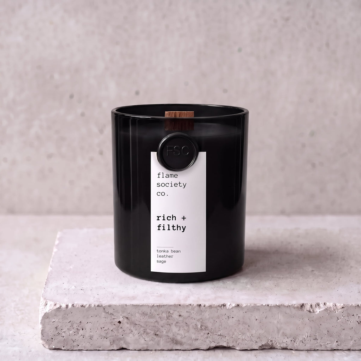 Rich + Filthy candle hero — black glass vessel with wooden wick, tonka bean, leather and sage — Flame Society Co.