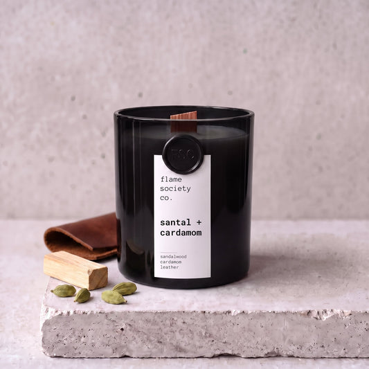 Santal + Cardamom candle styled with sandalwood, cardamom and leather on concrete — Flame Society Co.