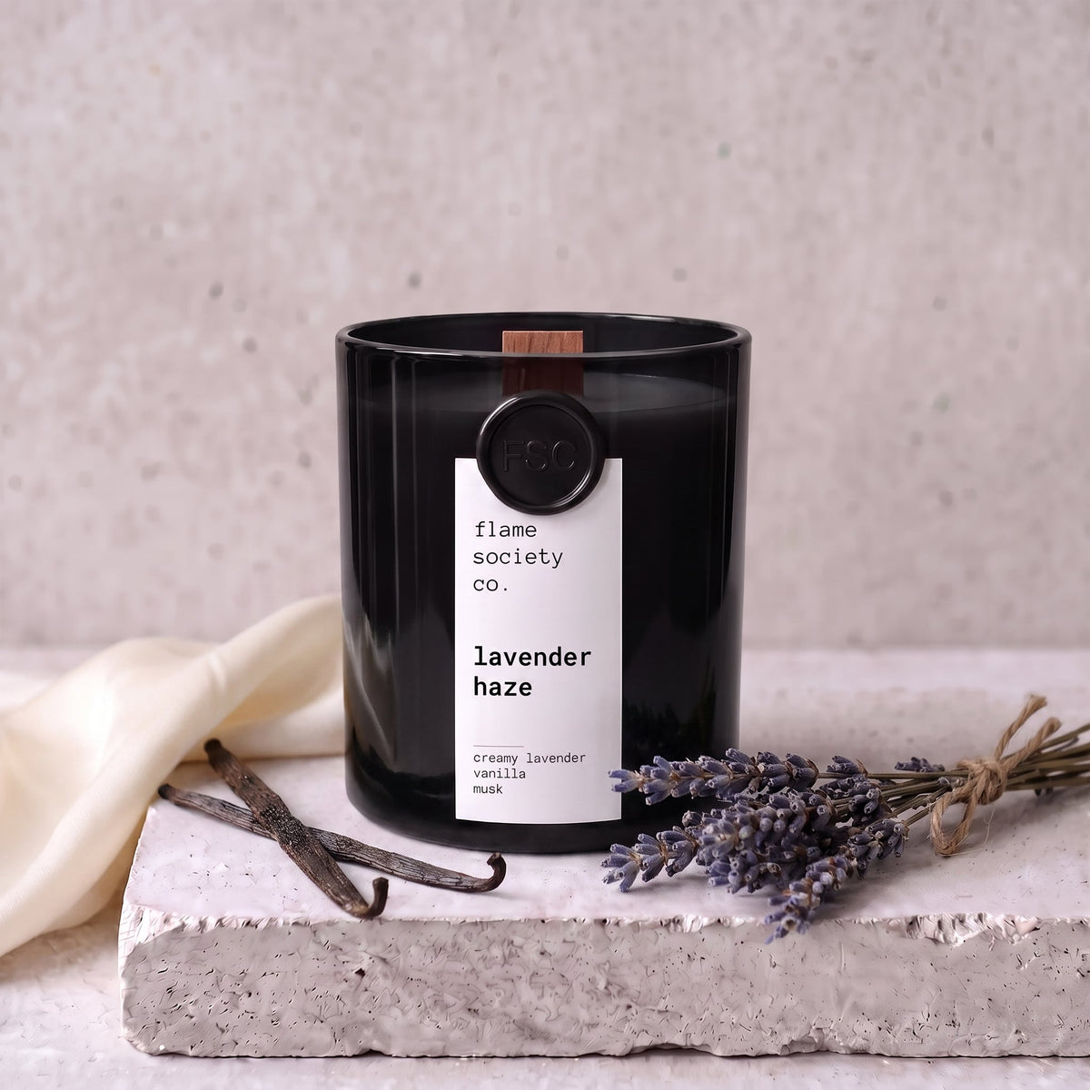 Lavender Haze candle styled with lavender, vanilla and silk on concrete — Flame Society Co.
