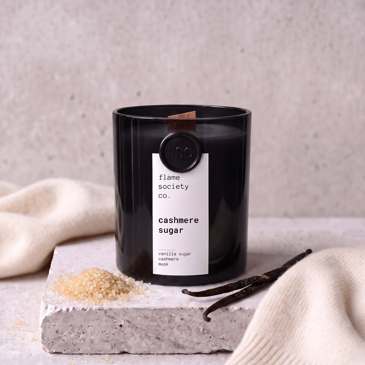 Cashmere Sugar candle styled with sugar, vanilla and cashmere on concrete — Flame Society Co.