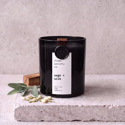 Sage + Silk candle styled with sage, white tea and cedarwood on concrete — Flame Society Co.
