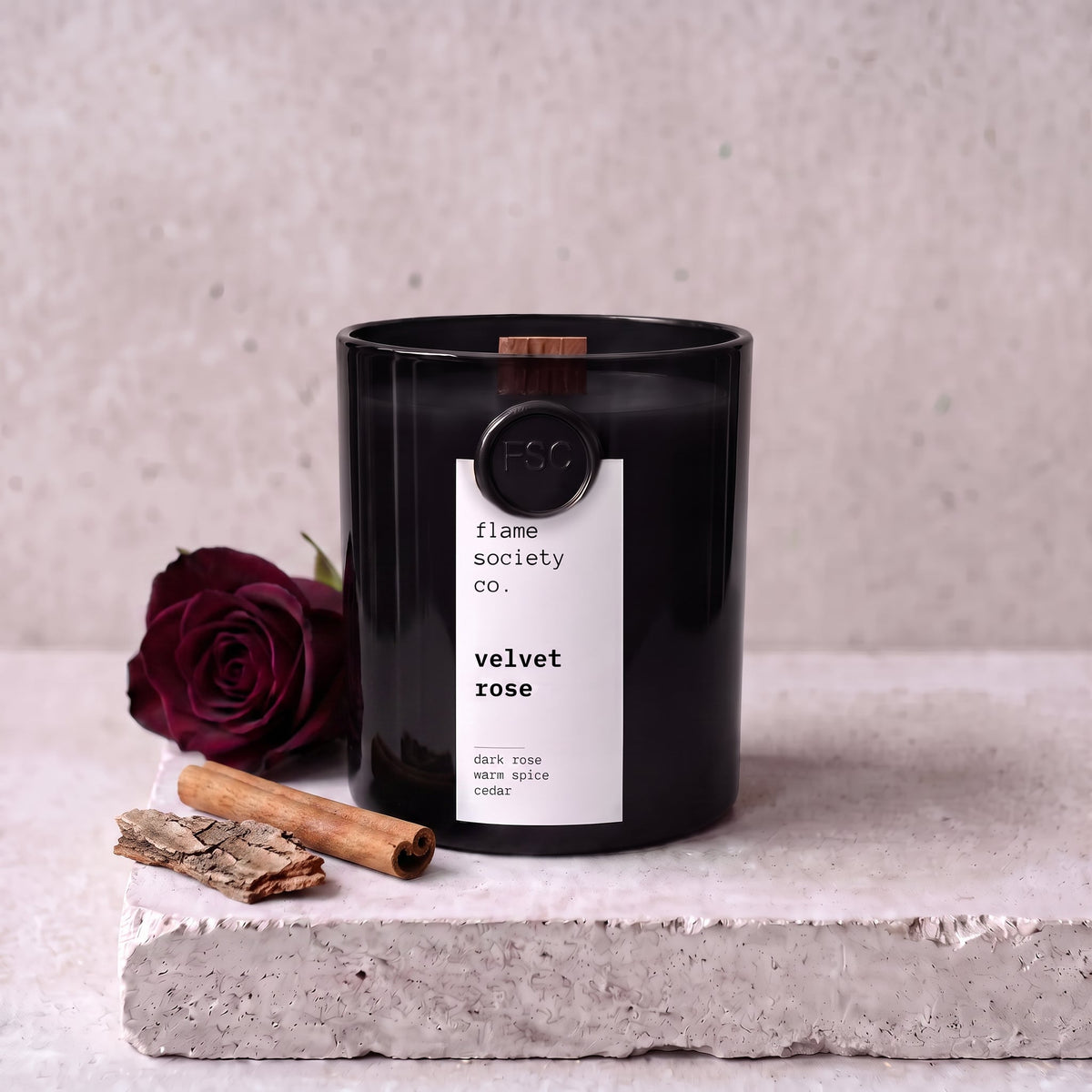 Velvet Rose candle styled with dark rose, cinnamon and cedar on concrete — Flame Society Co.