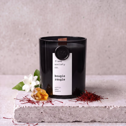 Bougie Rougie candle styled with saffron, amber and jasmine on concrete — Flame Society Co.