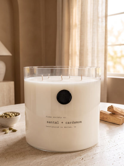 Santal + Cardamom XL 150oz statement candle in a clear glass vessel with wick snuffer — Flame Society Co.