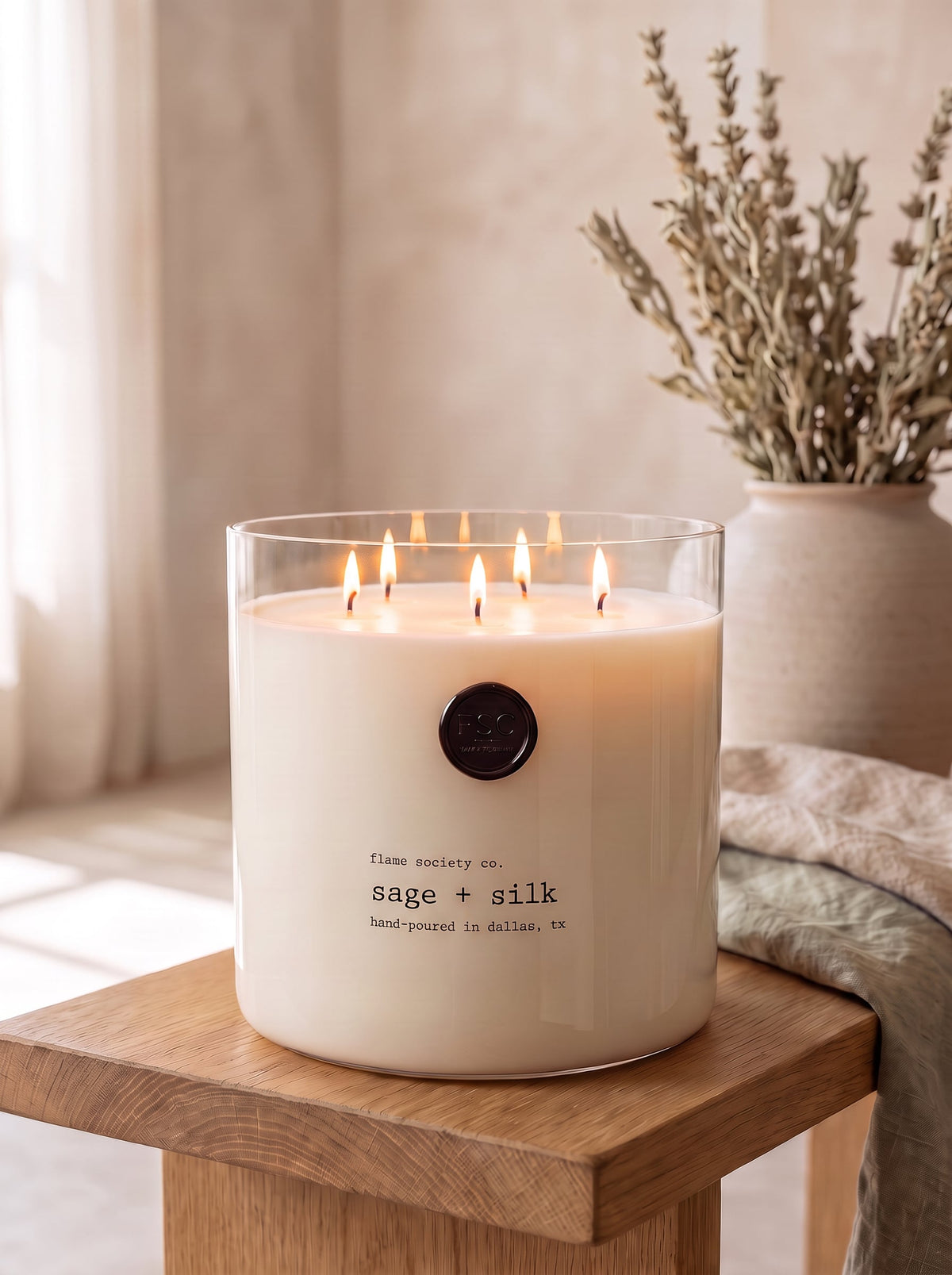 Sage + Silk XL 150oz statement candle in a clear glass vessel in a minimal japandi room — Flame Society Co.